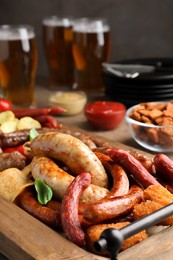 Set of different tasty snacks and beer on wooden table, closeup view