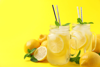 Freshly made natural lemonade on yellow background. Summer refreshing drink