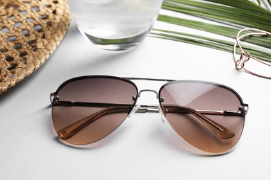 New stylish sunglasses on white table, closeup