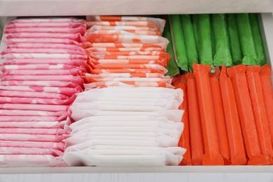 Storage of different feminine hygiene products in drawer, closeup