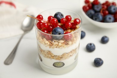 Delicious yogurt parfait with fresh berries on white table, closeup