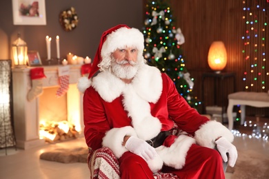 Santa Claus sitting in armchair at home. Christmas surprise for child