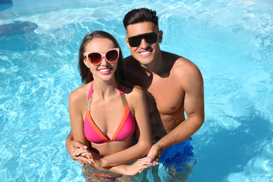 Happy couple in outdoor pool on sunny summer day