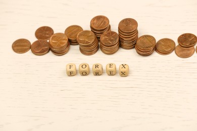 Word Forex with cubes and stacked coins on white wooden table