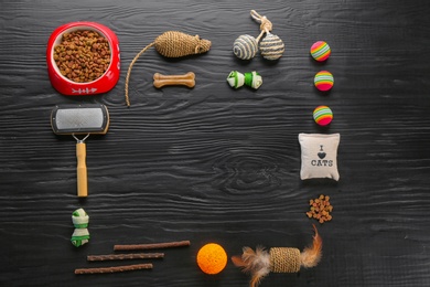 Flat lay composition with cat accessories and food on dark wooden background