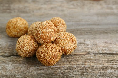 Photo of Delicious sesame balls on wooden table. Space for text
