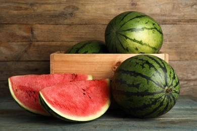 Delicious ripe whole and cut watermelons on wooden table