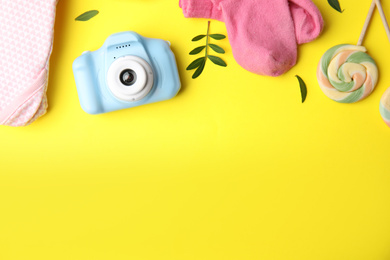 Flat lay composition with toy camera on yellow background, space for text. Future photographer