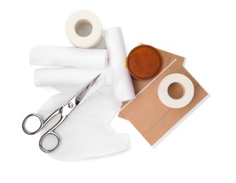 Bandage rolls and medical supplies on white background, top view