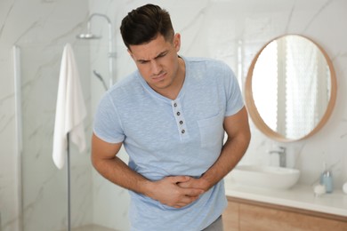 Man suffering from stomach ache in bathroom. Food poisoning