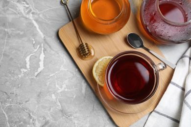 Photo of Flat lay composition of tea with honey on light grey marble table. Space for text