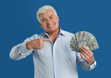 Photo of Happy senior man with cash money on blue background