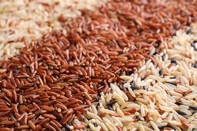 Mix of different brown rice as background, closeup
