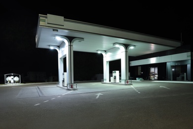 Modern gas station with convenience store beside the road at night