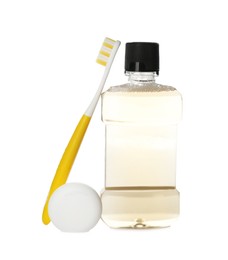 Bottle with mouthwash, dental floss and toothbrush on white background