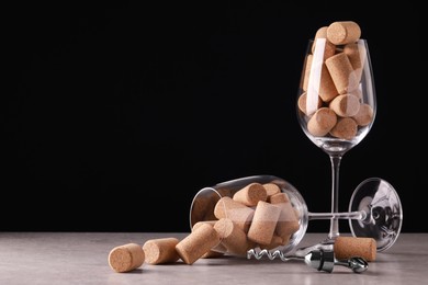Photo of Glasses with wine corks and corkscrew on light table. Space for text