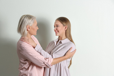 Mother and her adult daughter on white background