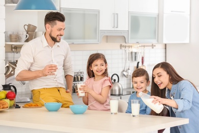 Happy family having breakfast with milk in kitchen