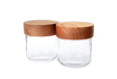 Two empty glass jars with wooden lids isolated on white