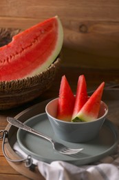 Fresh juicy watermelon and fork on wooden table