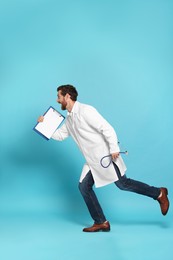 Photo of Doctor with stethoscope and clipboard running on light blue background