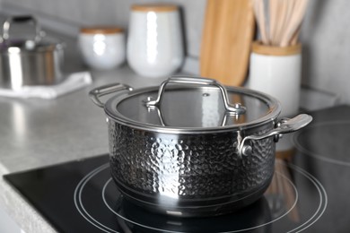 Pot with lid on cooktop in kitchen. Cooking utensil