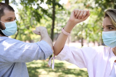 Man and woman bumping elbows to say hello outdoors, closeup. Keeping social distance during coronavirus pandemic