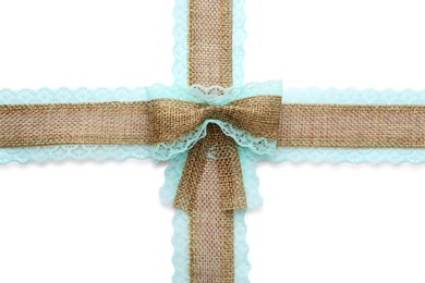 Burlap ribbons and bow with light blue lace on white background, top view