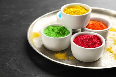 Colorful powder dyes on black background, closeup. Holi festival