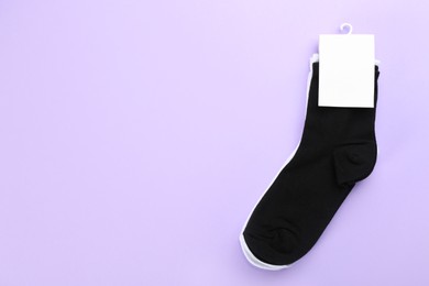 Soft cotton socks on lilac background, top view. Space for text