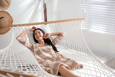 Young woman relaxing in hammock at home