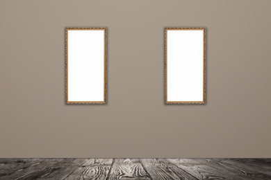 Frames with empty canvases on beige wall in modern art gallery. Space for design