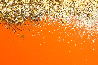 Shiny bright golden glitter on pale coral background. Space for text