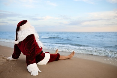 Santa Claus relaxing on beach, space for text. Christmas vacation