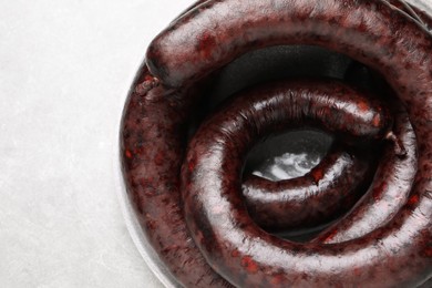 Tasty blood sausages on light grey table, top view