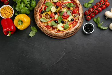 Flat lay composition with delicious hot vegetable pizza on black table. Space for text