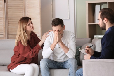 Family psychologist working with young couple in office
