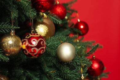 Beautifully decorated Christmas tree against red background, closeup