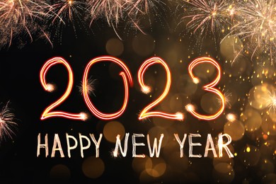 Bright text Happy New 2023 Year made of firework on dark background. Greeting card design