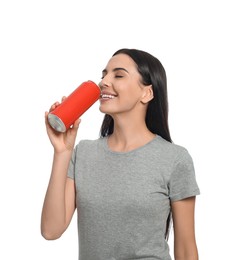 Photo of Beautiful happy woman drinking from red beverage can on white background