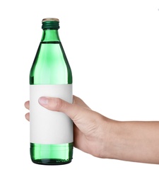 Woman holding glass bottle with soda water on white background, closeup