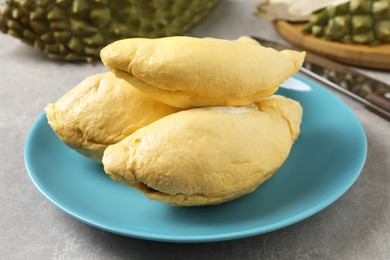 Photo of Plate with fresh ripe durian on grey table