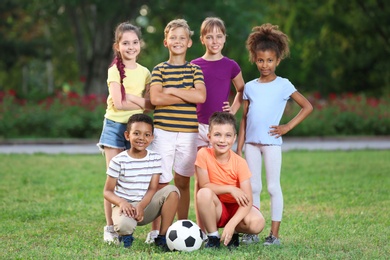 Cute little children with soccer ball in park. Outdoor play