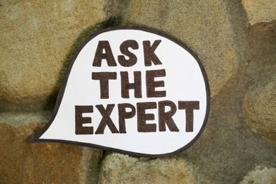Paper message bubble with phrase Ask The Expert on ground, top view