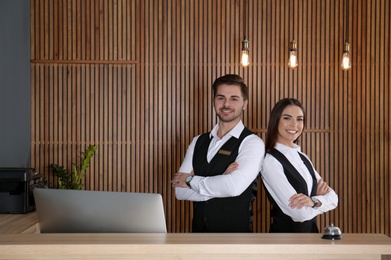 Smiling receptionists at desk in modern lobby