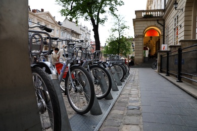 LVIV, UKRAINE - APRIL 27, 2019: Parking with bicycles for rent on Market Square near Town Hall
