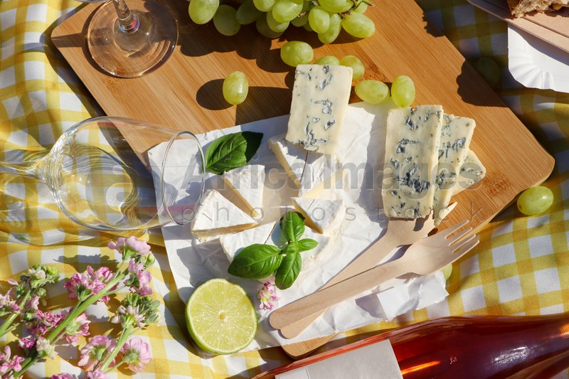 Delicious food and wine on picnic blanket, flat lay