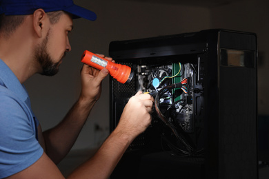 Repairman with flashlight fixing system unit indoors