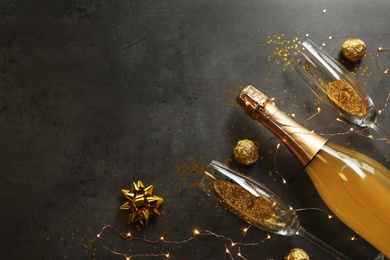 Flat lay composition with bottle of champagne for celebration on grey stone background. Space for text