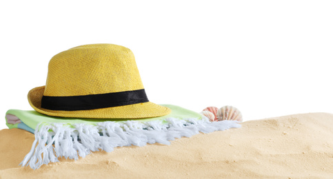 Folded towel, hat and shells on sand against white background. Beach objects